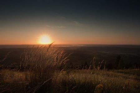 majestic sunset clouds and path through a mountain meadow to horizonの写真素材