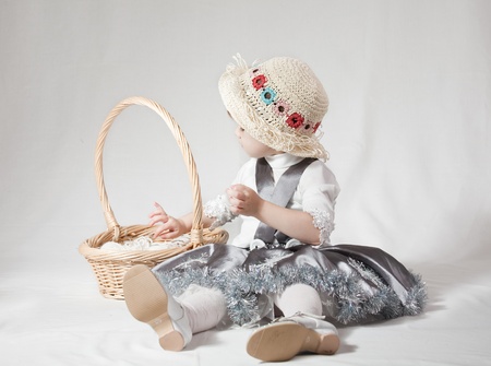 Young girl with a wicker basket on white backgroundの写真素材