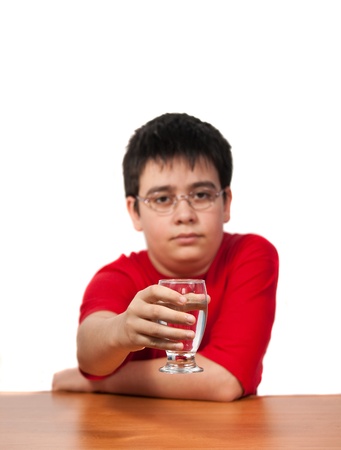 boy holds a glass of water on a white backgroundの写真素材