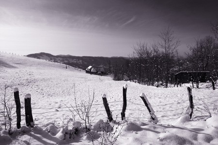 Old farm in the mountains at winterの写真素材