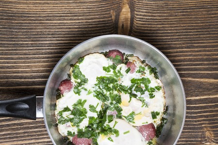 omelet in the pan on a brown wooden tableの写真素材