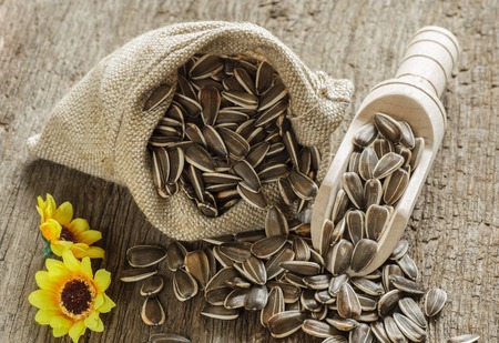 flower seeds in bag on old wooden tableの写真素材