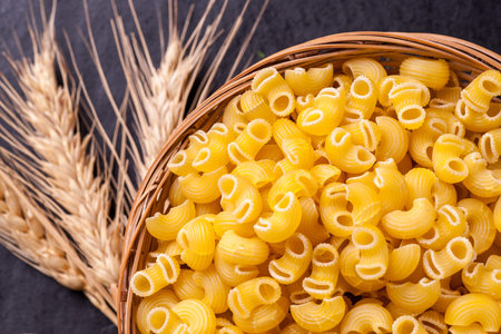 Raw pasta in bowl on a black table