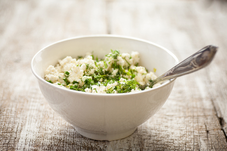 Cheese with dill in bowl on a wooden rustic  table. Selective focus.の写真素材