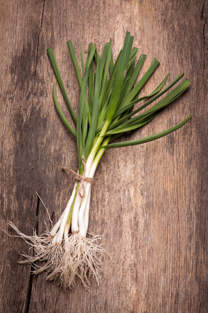 Young garlic on a old wooden table. Rustic style.の写真素材