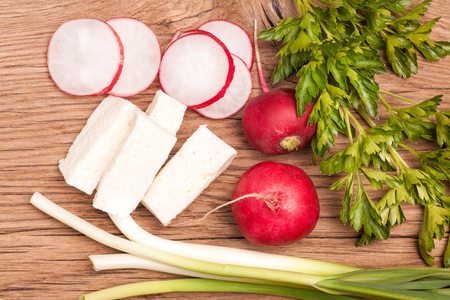 Radish, sheese and onion on old wooden table. Rustic style. Vegetarian foodの写真素材