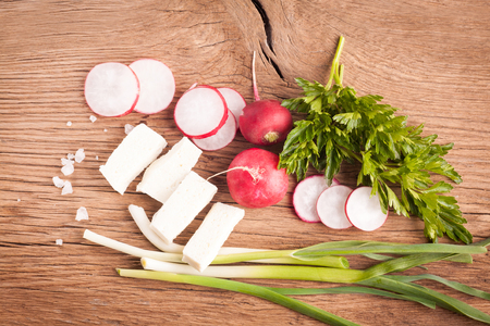 Radish, sheese and onion on old wooden table. Rustic style. Vegetarian foodの写真素材