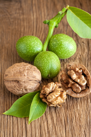 Young and old walnuts on wooden background.の写真素材