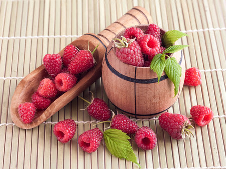 Rasberry in wooden bowl on wooden background. Natural food.