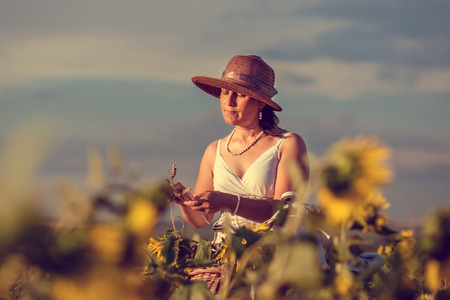Woman with bicycle in sunflowers fieldの写真素材
