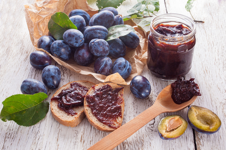 Fresh plums with homemade jam on wooden tableの写真素材