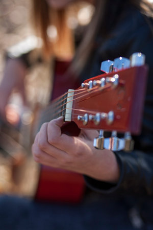 Portrait of a girl with a guitar in the autumn park