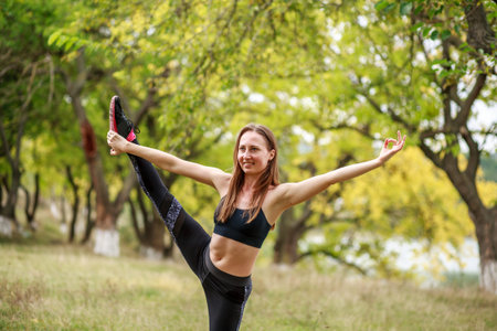 Happy young woman practicing yoga on the nature