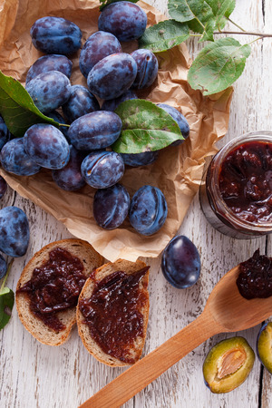 Fresh plums with homemade jam on wooden tableの写真素材