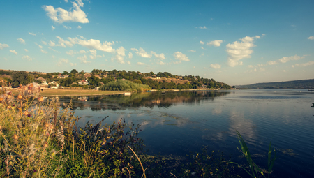 summer landscape with river, blue sky and reflectionsの写真素材
