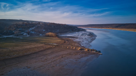 Arial view over the river and small village at sunset. Dniester river of Moldova republic.