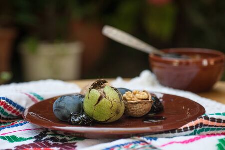 Fresh and dried prunes on plate.の写真素材