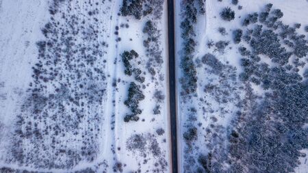 Country road going through the beautiful snow covered landscapes. Aerial view. Drone photographyの写真素材