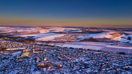 Top view of city suburbs or small town nice houses on winter sunset on cloudy sky background. Aerial drone photography concept.の写真素材
