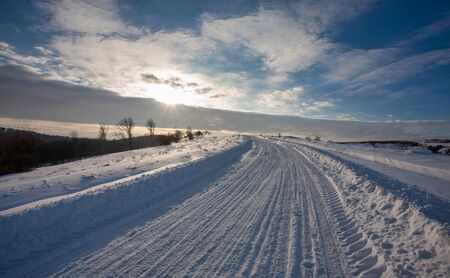 Empty snow covered road in winter landscapeの写真素材