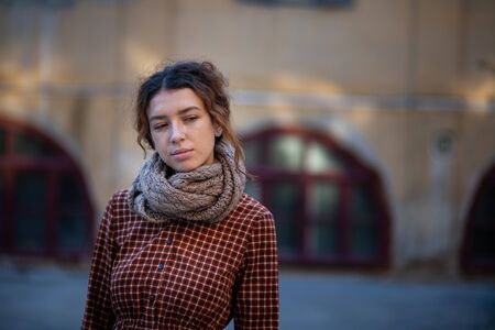 Dreaming young woman with spectacular curly red ginger hair looking at camera posing outdoor in downtown street. Female portrait.の写真素材