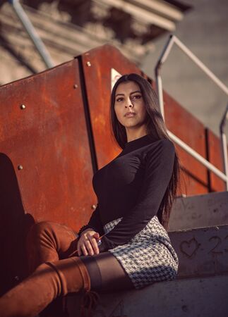 stylish girl model posing sitting on the steps of the buildingの写真素材