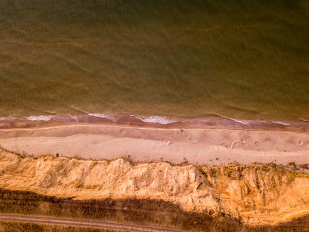 Aerial view of sandy beach and sea with waves