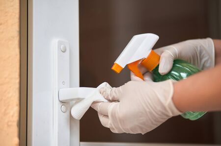 Decontaminating the surface of the door handle. Coronavirus prevention, hygiene to stop spreading coronavirus.の写真素材