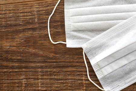 Medical masks are laid out on a wooden table. Concept of protection against virus, bacteria, dust.の写真素材