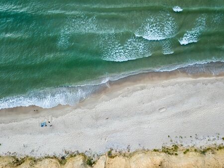 Aerial view of sandy beach and sea with wavesの写真素材