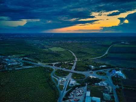 Aerial high drone flight over evening road traffic. Highway and overpass with cars and trucks, interchange, two-level road junctio. Freeway, line.の写真素材
