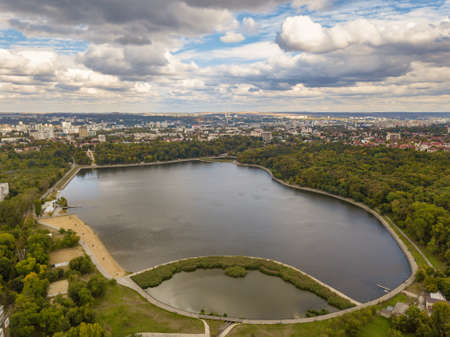 Aerial view of a lake in a park with autumn trees. Kishinev, Moldova. Epic aerial flight over water. Colorful autumn trees in the daytime.の写真素材