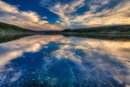 Magical Sunset Over the Riveer. Colorful sky under sunlit reflected in water. Wonderful Natural...