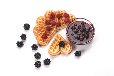 Belgium waffles with fresh berries and jam isolated on white backgroundの写真素材