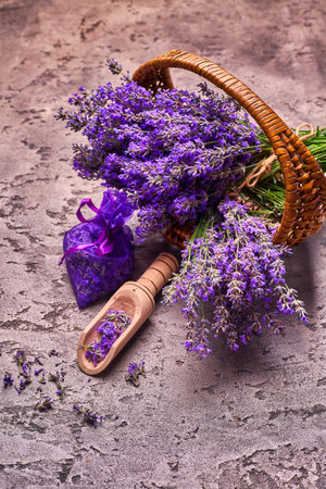 Lavender flowers in basket and aromatic bag on gray concrete background. Top view.の写真素材