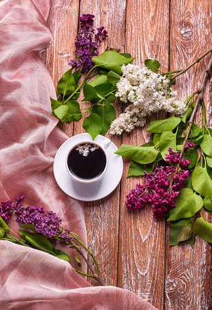 Coffee Cup And Colorful Lilac Flowers On Garden wooden Tableの写真素材