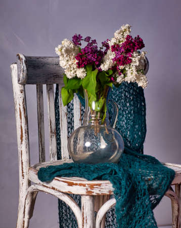 Lillac bouquet in vase on Vintage wooden chairの写真素材