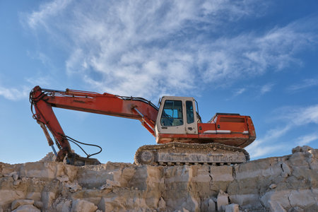 Excavator stands on the bacExcavator stands on the background of a stone quarry.kground of a stone...