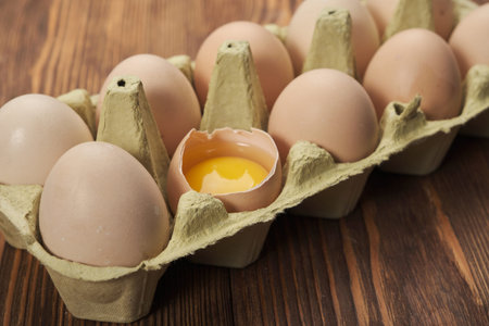 Cardboard egg box on wooden table. Top view