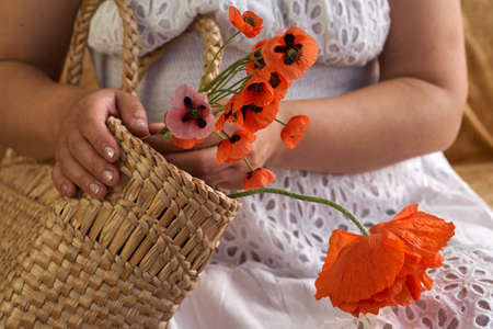 Woman in white dress holding poppe flowers, close up on her hands. Spring time dreams.の写真素材