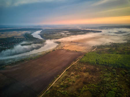 River scenery in the early morning. A hut in far away, and the tree covered by mystical fog, very quiet and tranquil. Moldova republic of.の写真素材