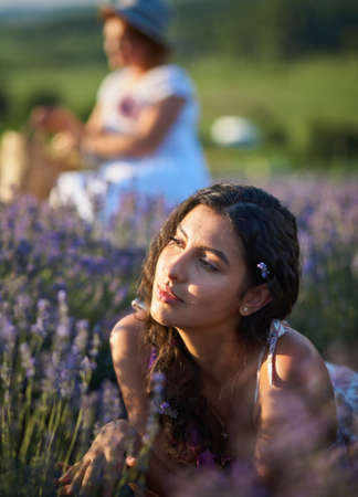 Young woman lying in lavender field on summer dayの写真素材