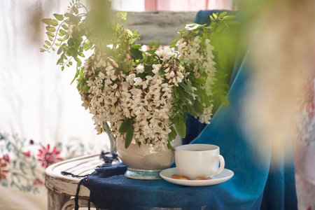 Acacia flowers in white vase. Still life wit acacia flowers on vintage shair.