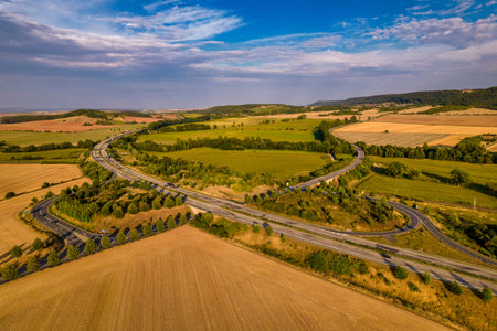 Aerial bird view of typical Ardennes green field meadows and hill landscape also showing highway and...