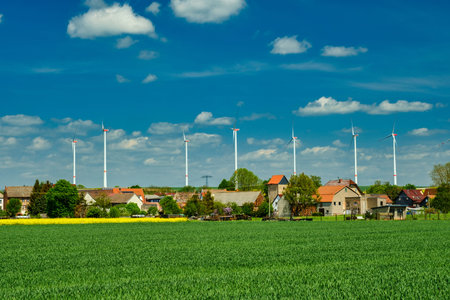 Wind electric turbines in agricultural wheat field in countryside. Deutchland.