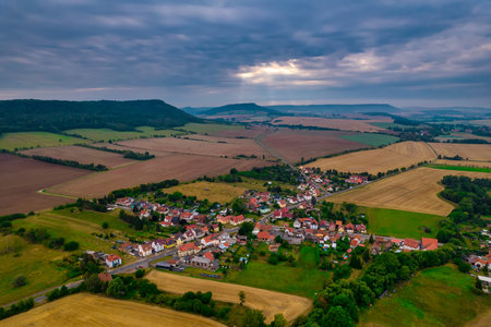 Aerial view of a German village surrounded by meadows, farmland and forest in Germany.の写真素材
