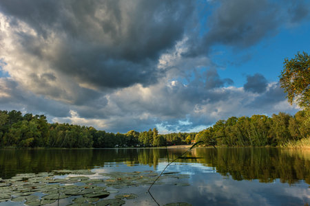 Natural landscape of the lake, high definition, the movement of waves against the background of the autumn forest. The reflection of clouds on the ripples of water. Germany.の写真素材