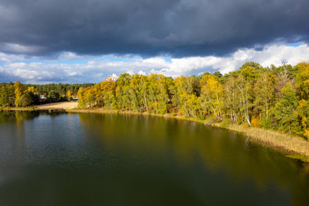 Aerial shot of beautiful lake surrounded by forest in a calm autumn day. Germany.の写真素材