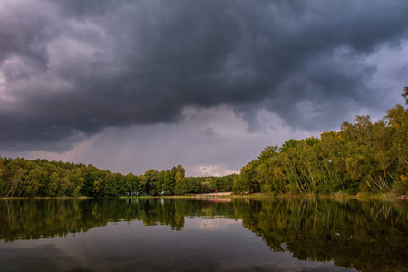 Natural landscape of the lake, high definition, the movement of waves against the background of the autumn forest. The reflection of clouds on the ripples of water. Germany.の写真素材