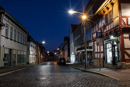 Bleicherode, Germany - 08/17/2023: Street alley in the small town of Schwabisch Hall, with houses and buildings with typical German architecture and street lanterns, at night.のeditorial素材